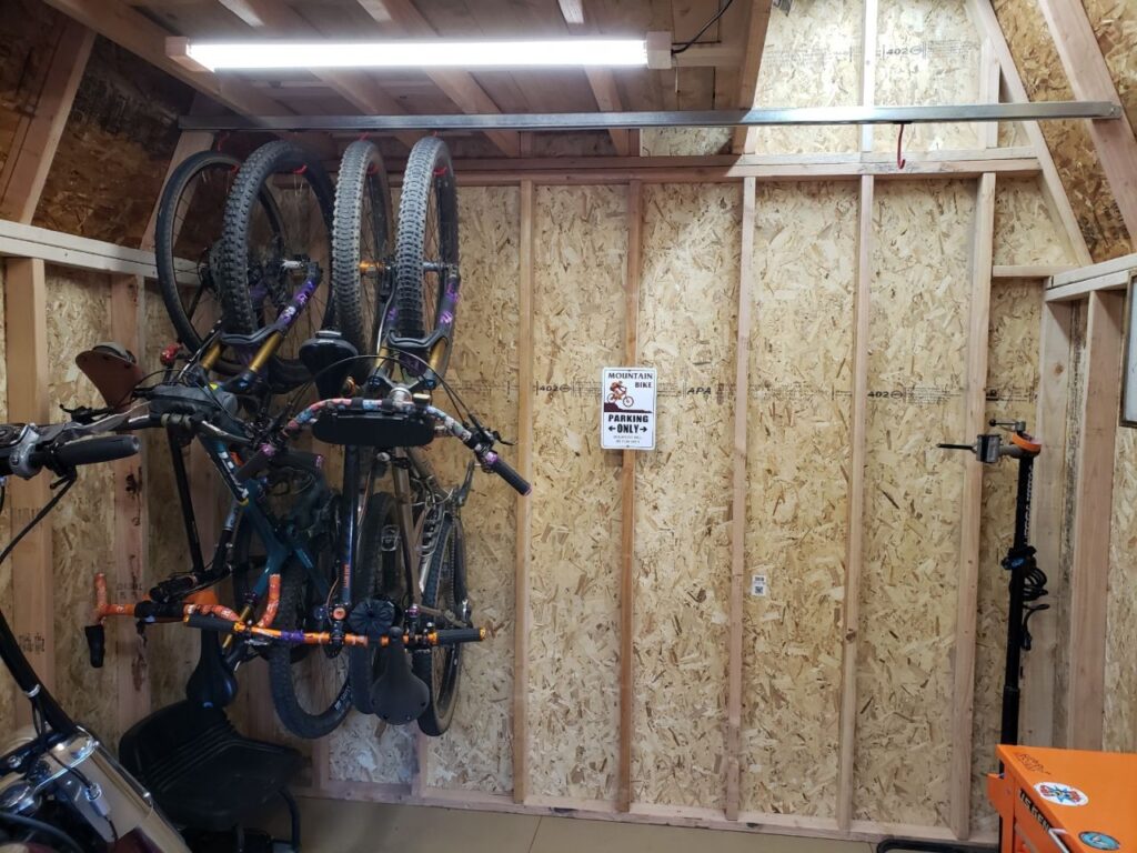 Bikes hanging close together on unistrut trolley hooks